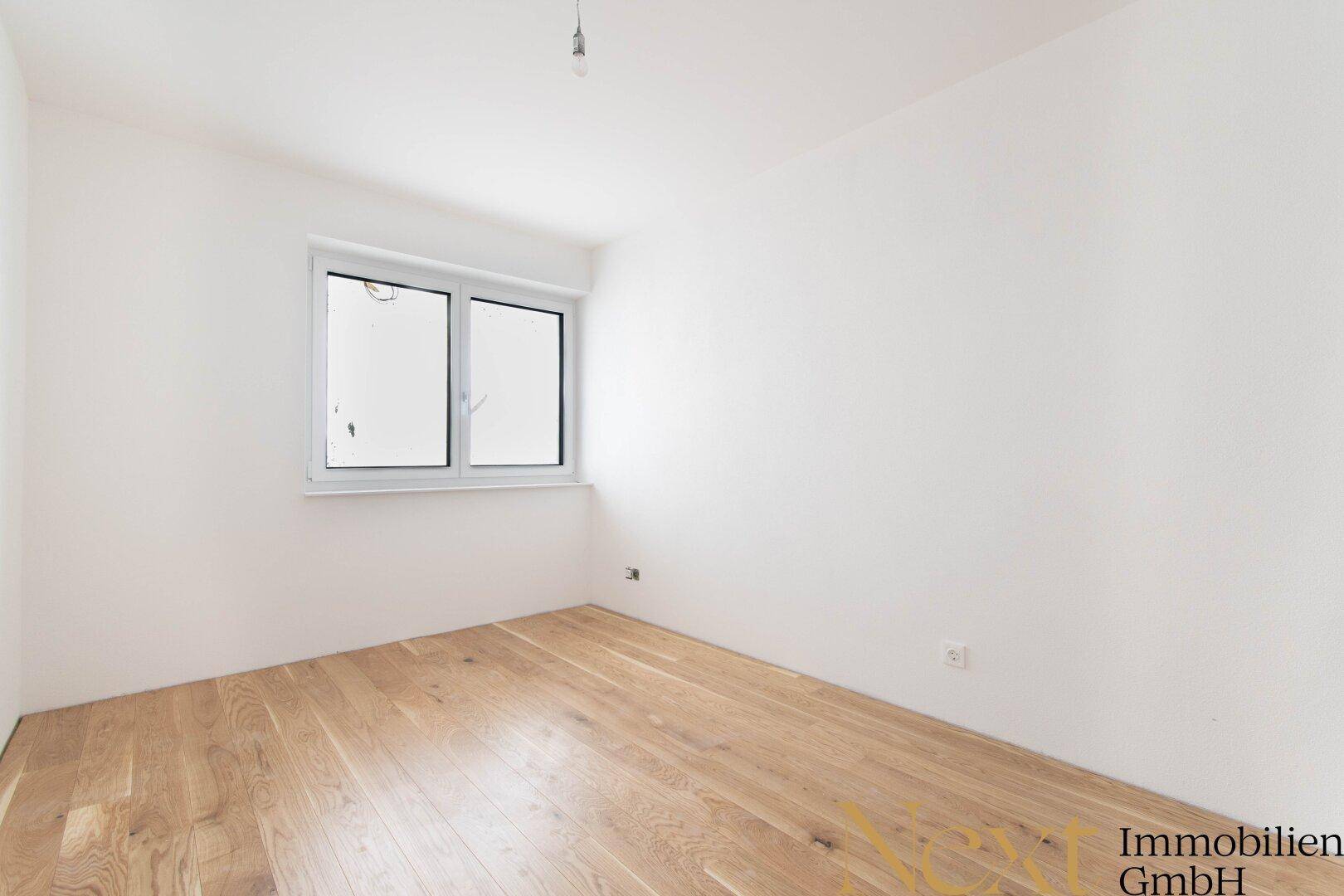 Heller, unmöblierter Raum mit Holzboden und Fenster, ideal als Schlaf- oder Arbeitszimmer.