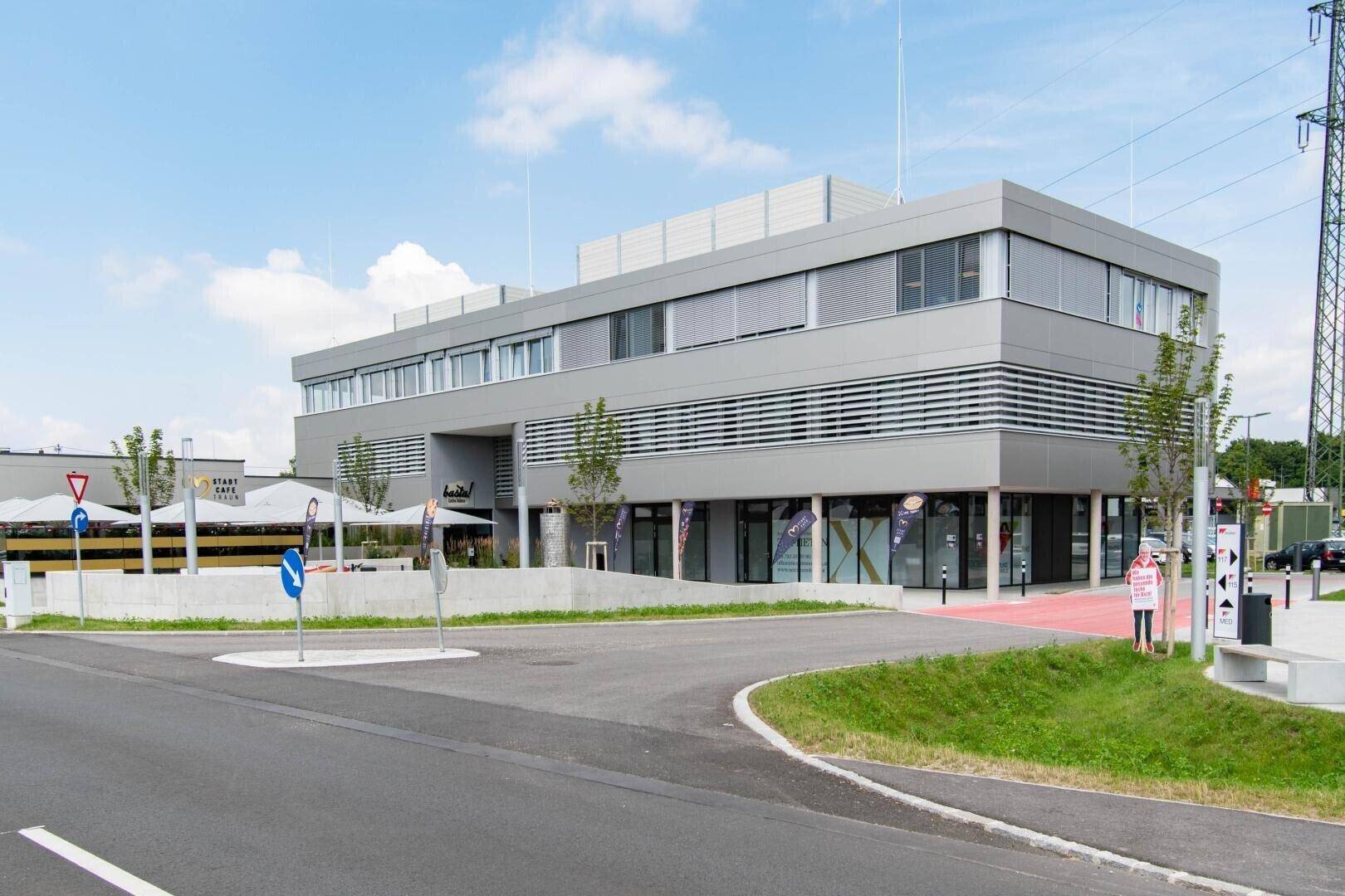 Zeitgenössisches Geschäftsgebäude mit moderner Architektur und umliegenden Parkplätzen.