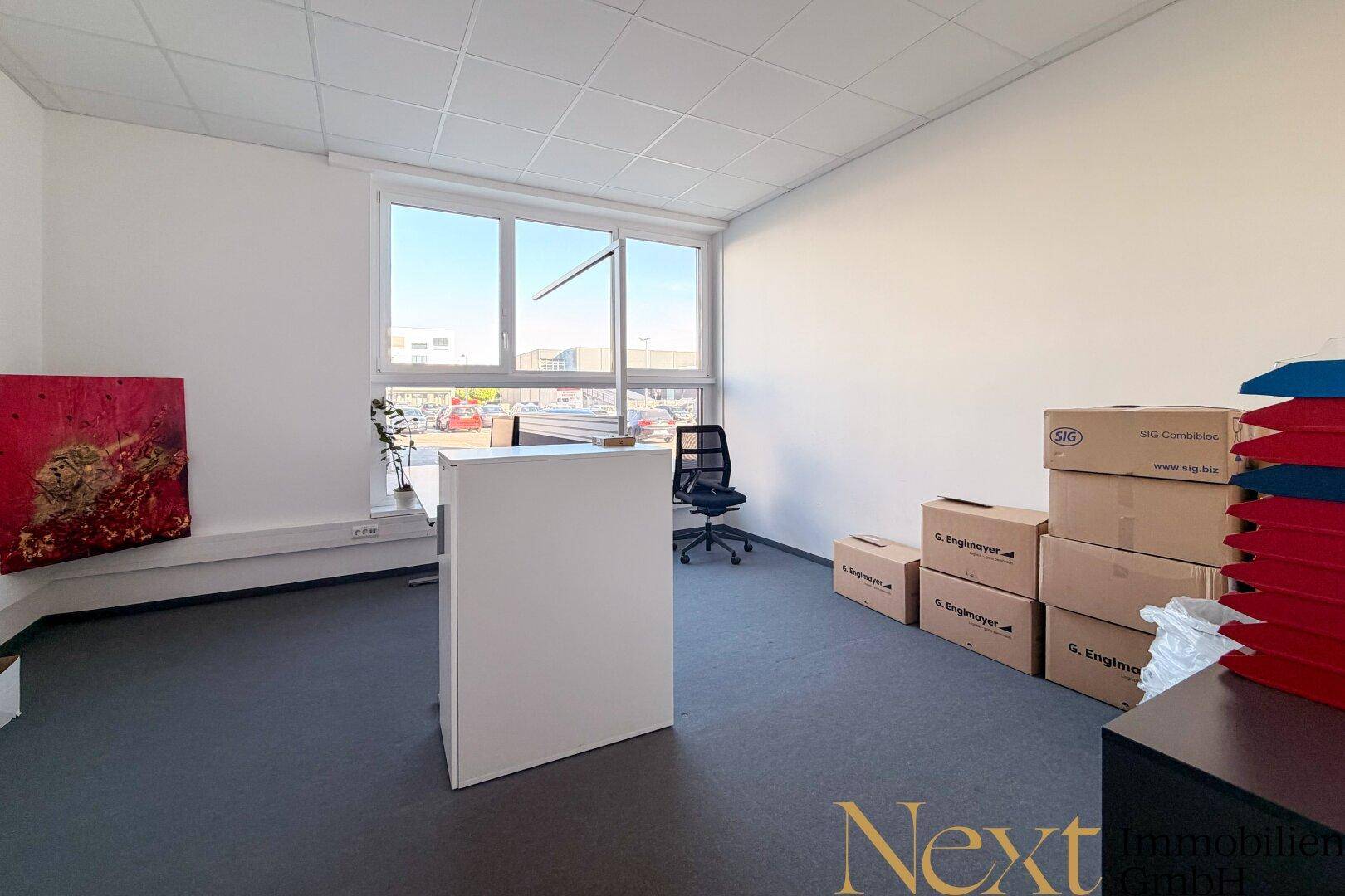 Geräumiges Büro mit großen Fenstern, Blick nach draußen und viel Tageslicht.