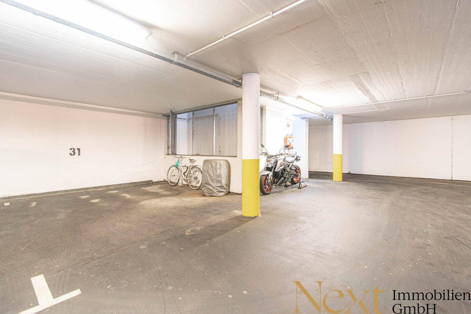 Geräumige Tiefgarage mit markierten Stellplätzen und Beleuchtung.