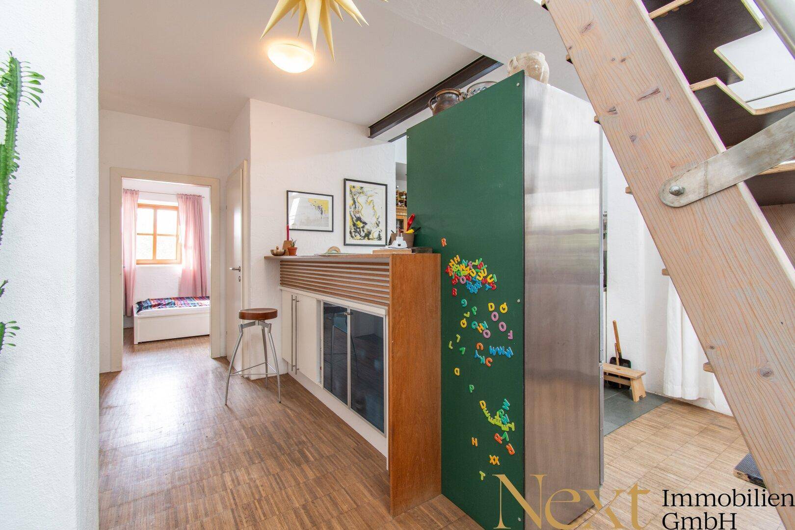 Heller Flur mit Holzboden und Blick in ein angrenzendes Schlafzimmer, mit dekorativer Wand.