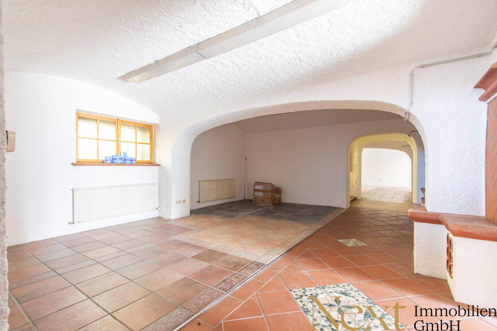 Rustikaler Kellerraum mit Gewölbedecken, Terrakottafliesen und einem kleinen Fenster.