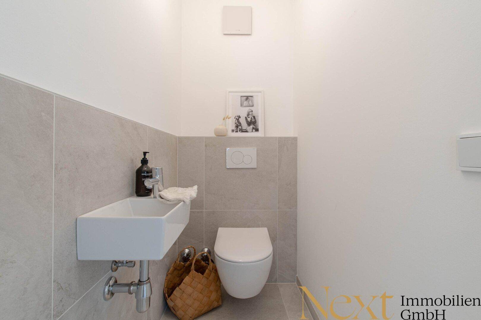 Modernes Gäste-WC mit Wand-WC und kleinem Waschbecken.