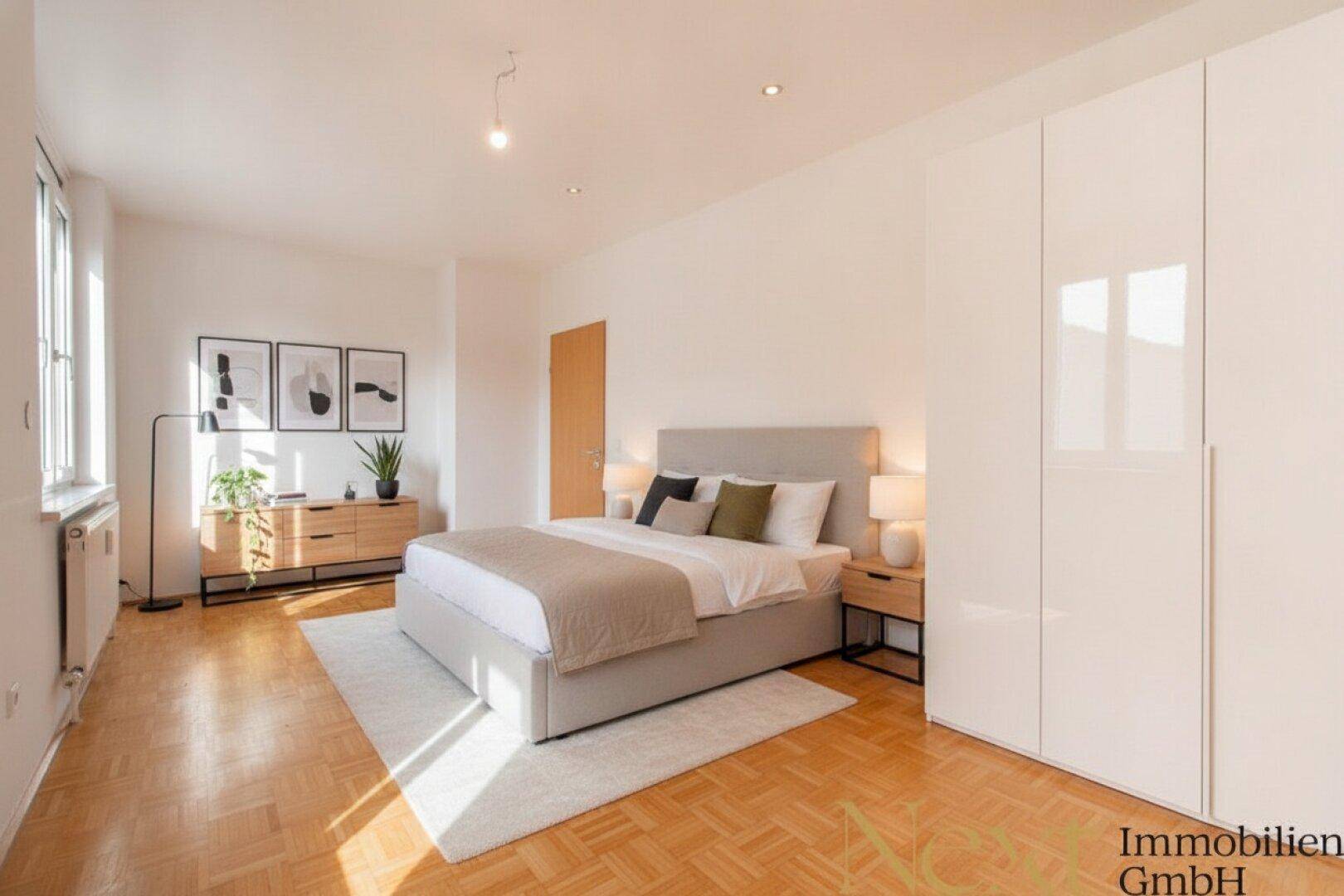 Geräumiges Schlafzimmer mit großem Bett, Einbauschrank und Parkettboden, bietet viel Stauraum und Komfort.