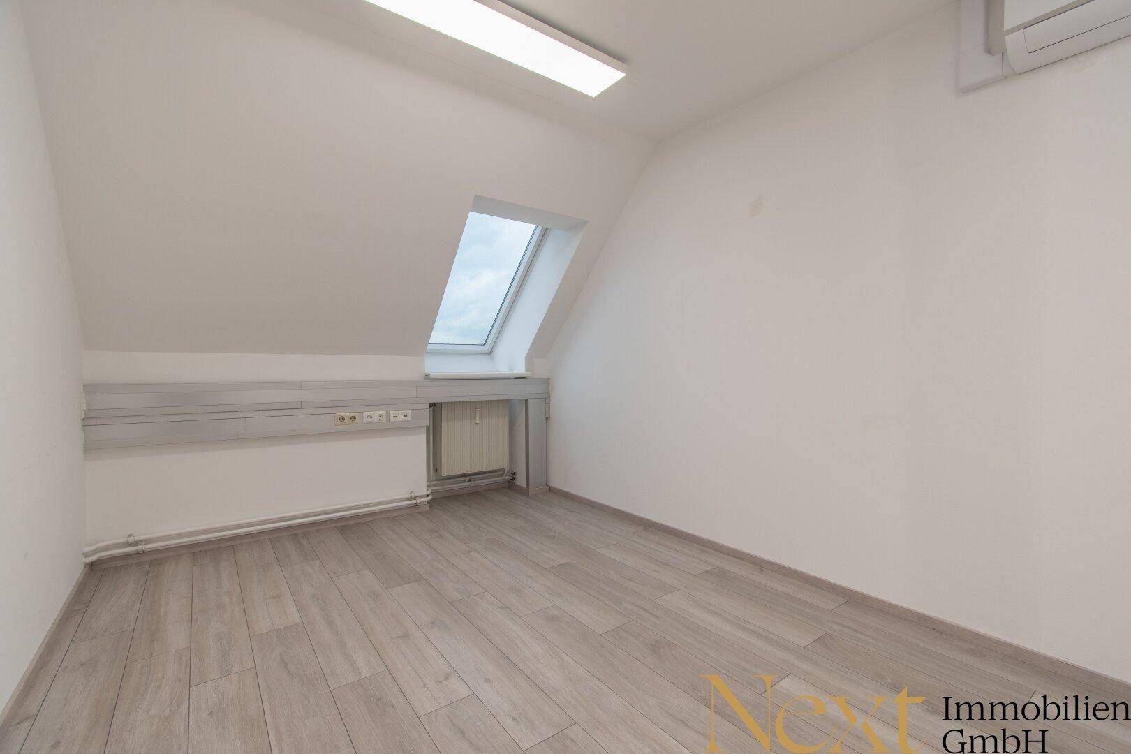 Kleinerer Büroraum mit einem Dachfenster und hellem Laminatboden, geeignet als Einzelbüro.
