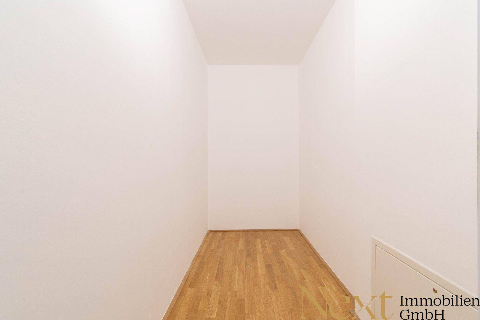 Kleiner, leerer Raum mit Parkettboden, ideal als Abstellraum oder begehbarer Kleiderschrank.
