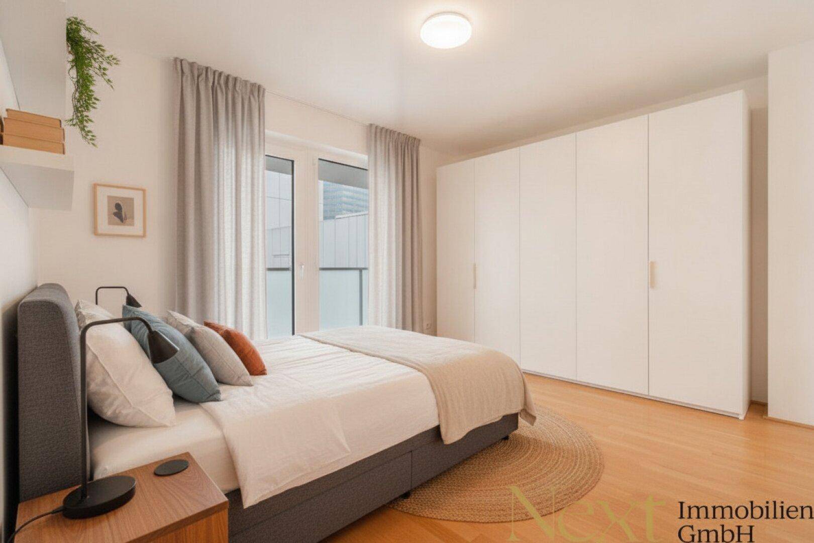 Modernes Schlafzimmer mit großem Bett, Einbauschränken und Zugang zum Balkon.