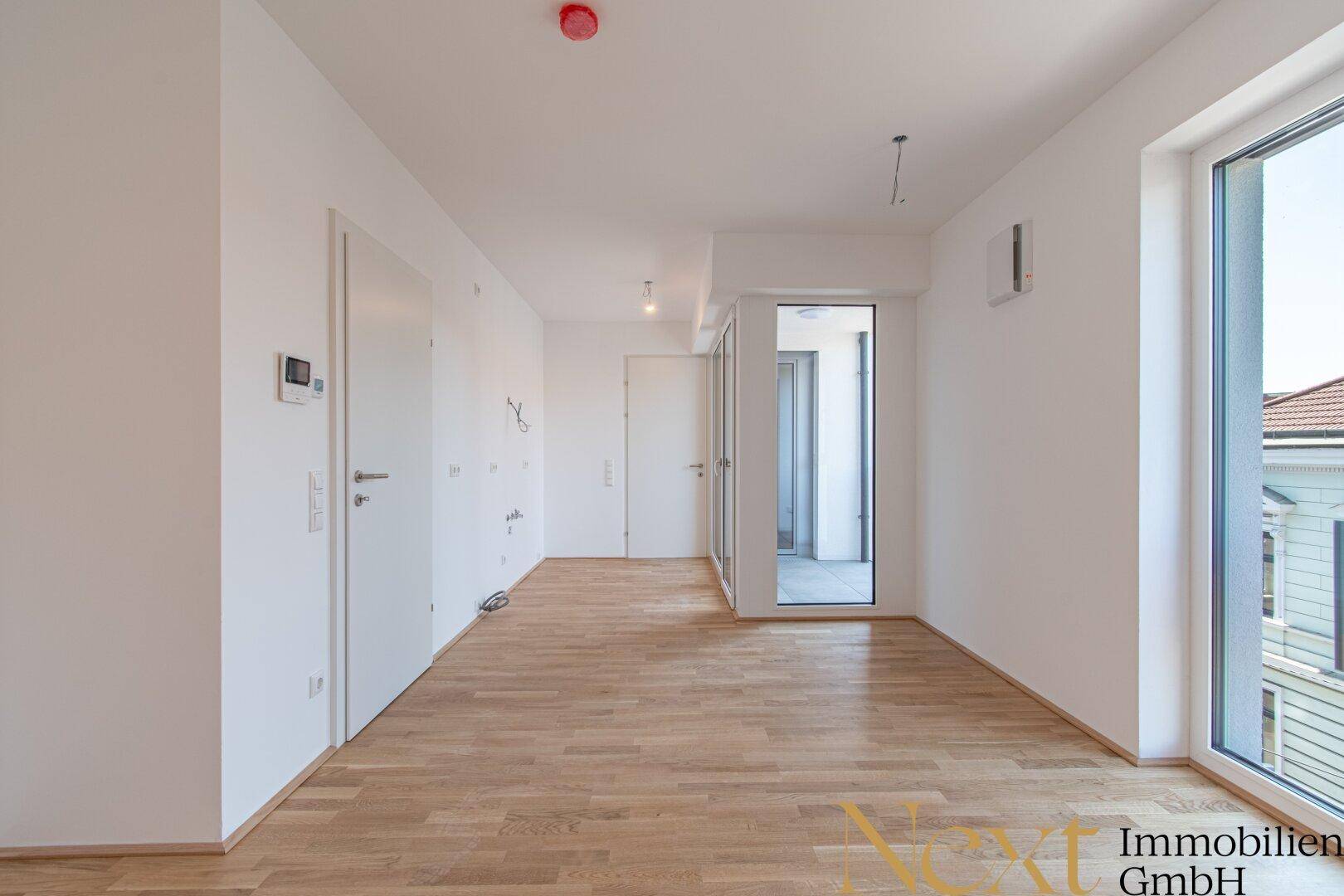 Geräumiges, helles Zimmer mit hellem Parkettboden und großen Fenstern, bereit zum Einrichten.