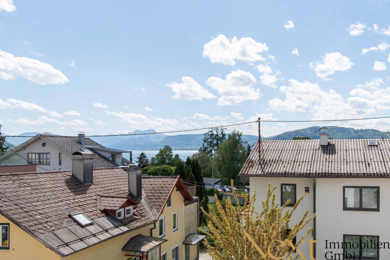 Malerischer Ausblick über die Dächer der Nachbarschaft zum See und den majestätischen Bergen.