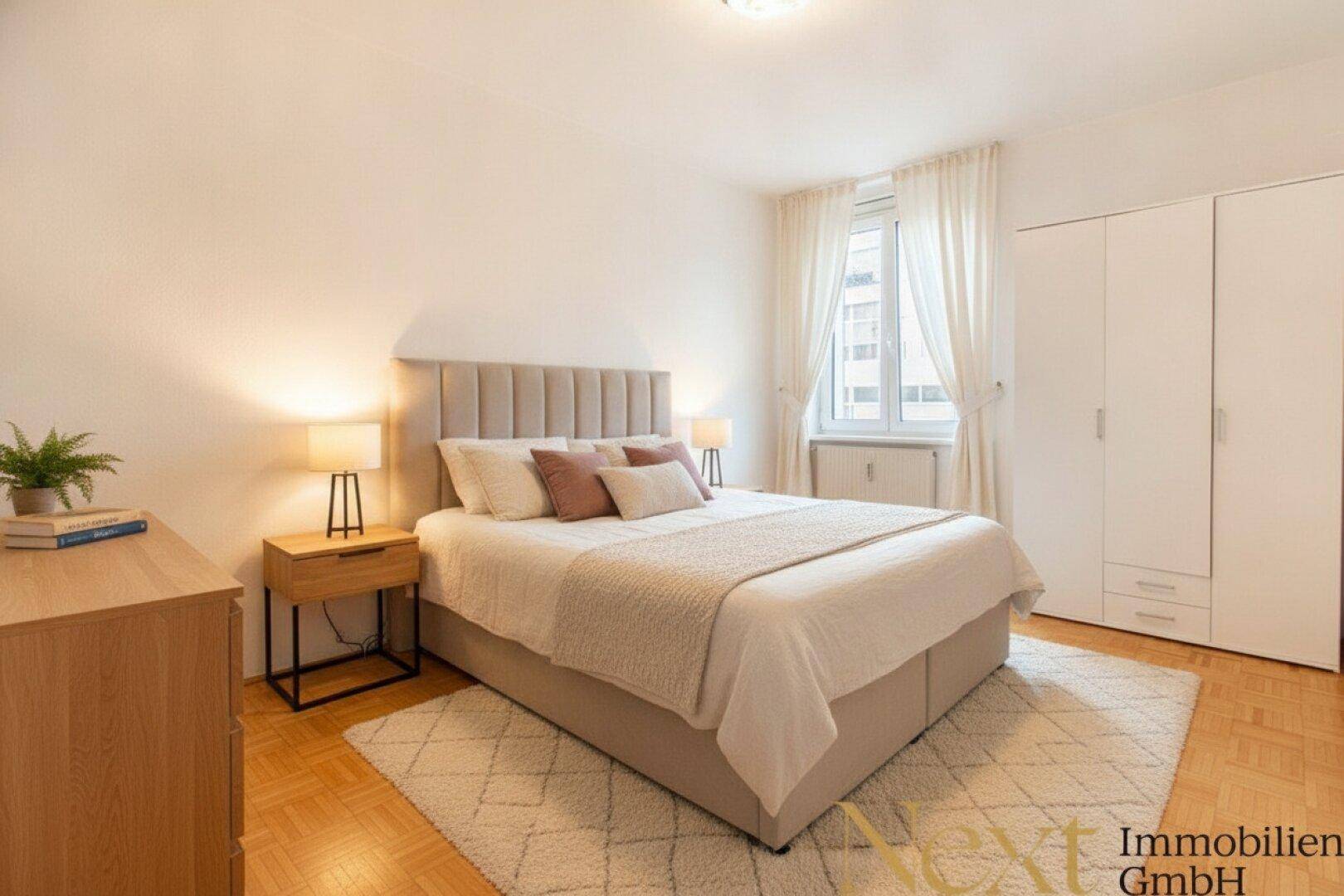 Gemütliches Schlafzimmer mit Doppelbett, Nachttischen und weißem Kleiderschrank, hell beleuchtet.