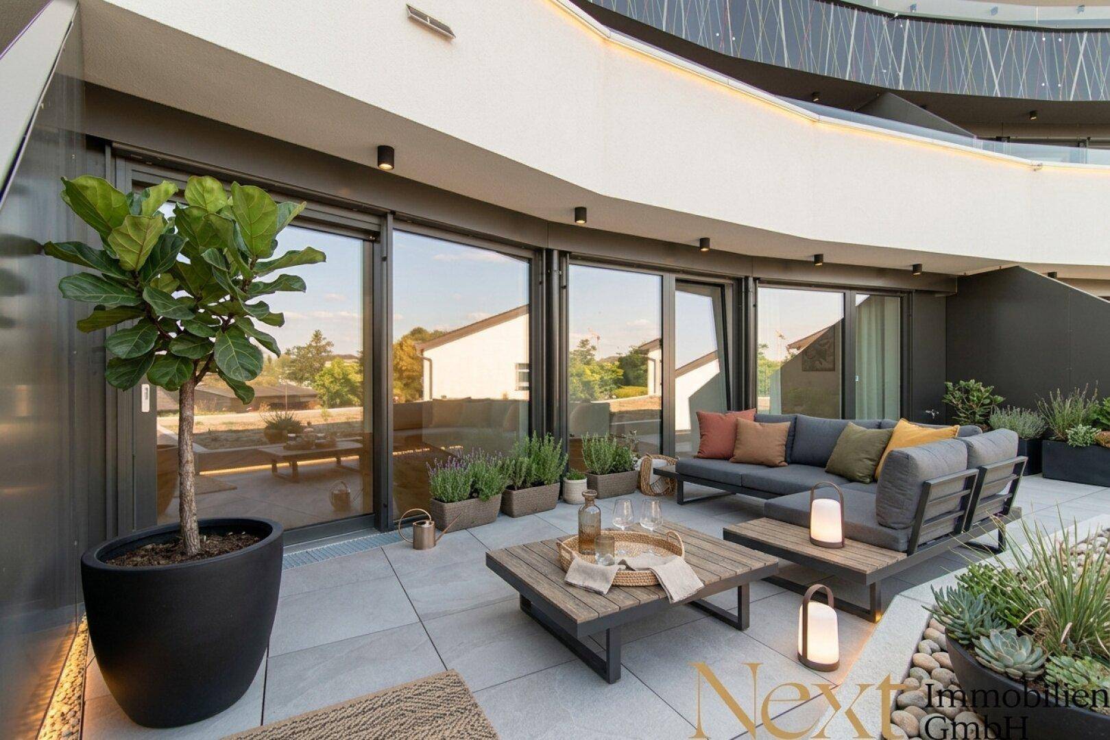 Große, möblierte Terrasse mit Pflanzen und bequemen Sitzgelegenheiten für entspannte Stunden.