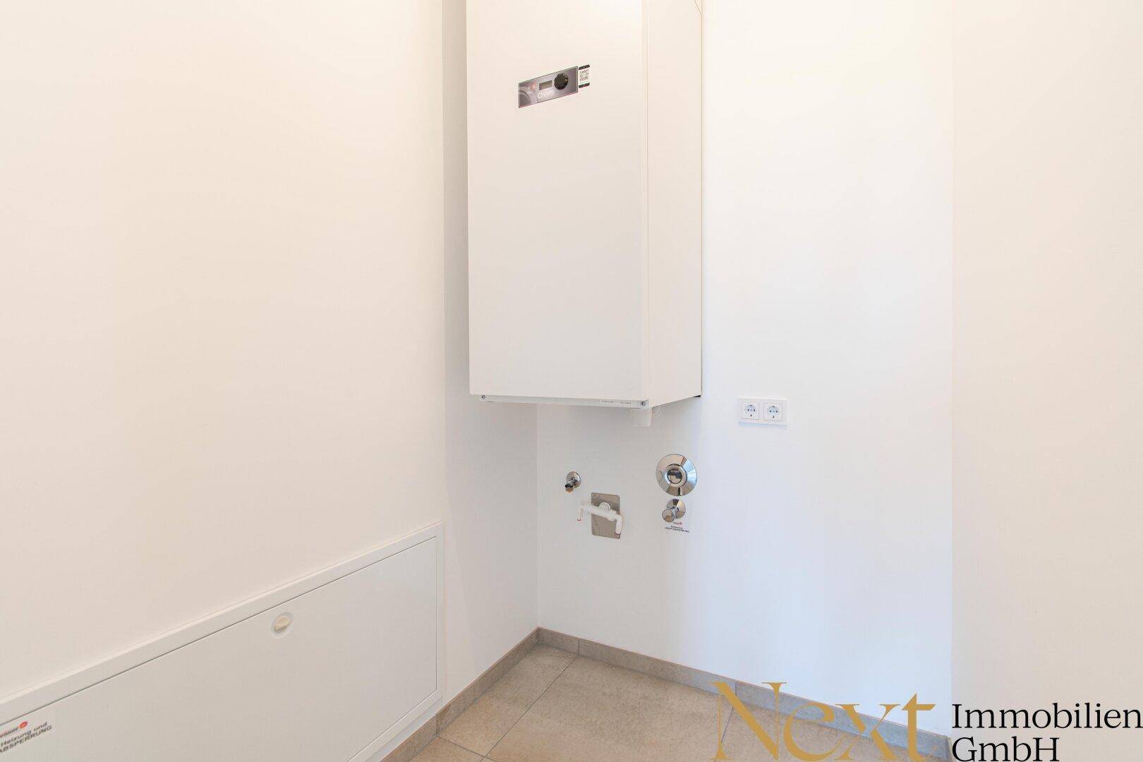 Funktionaler Hauswirtschaftsraum mit Heizungsanlage und Anschlüssen für Waschmaschine.