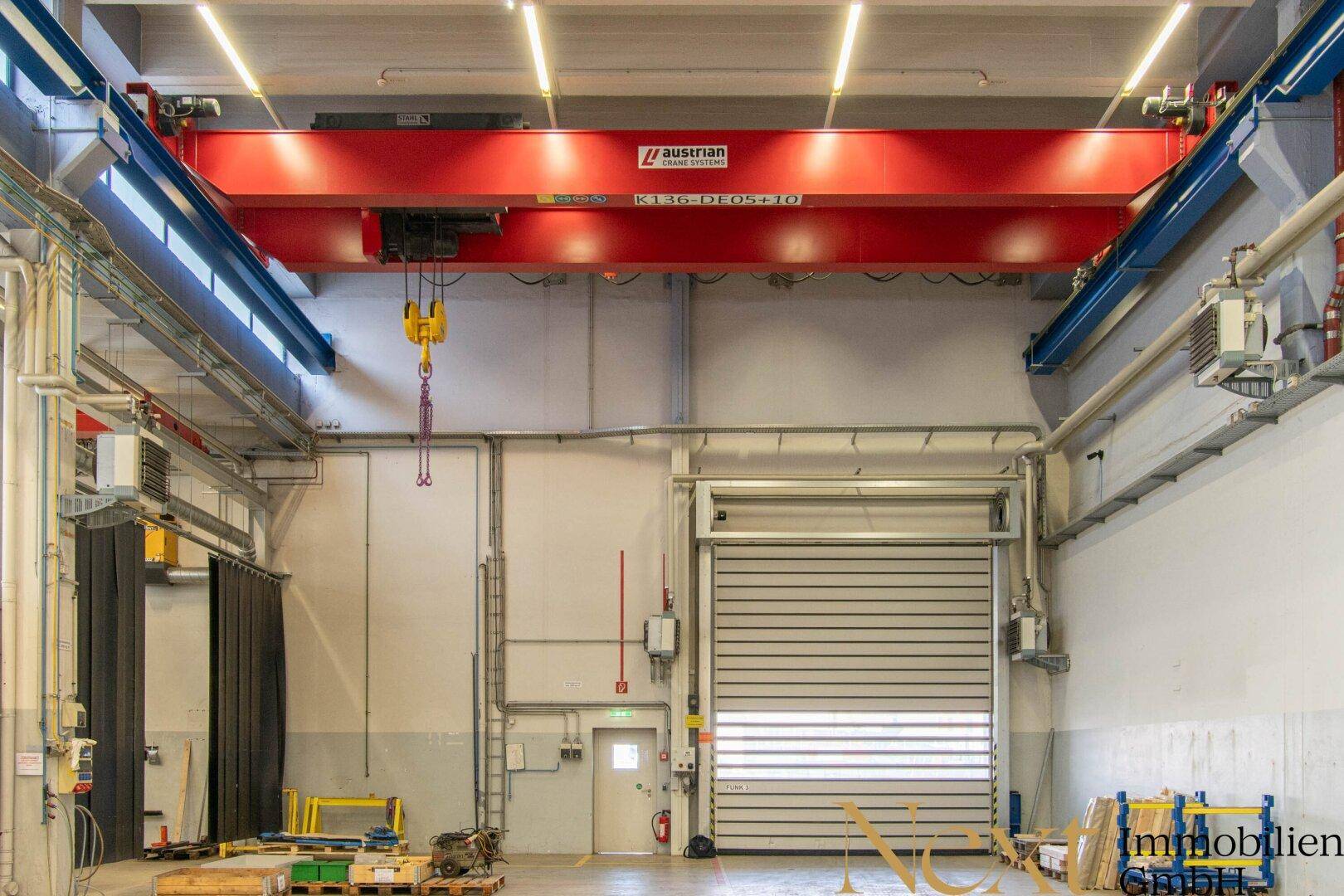 Detailansicht des großen Hallenkrans und des Rolltors in der Industriehalle.