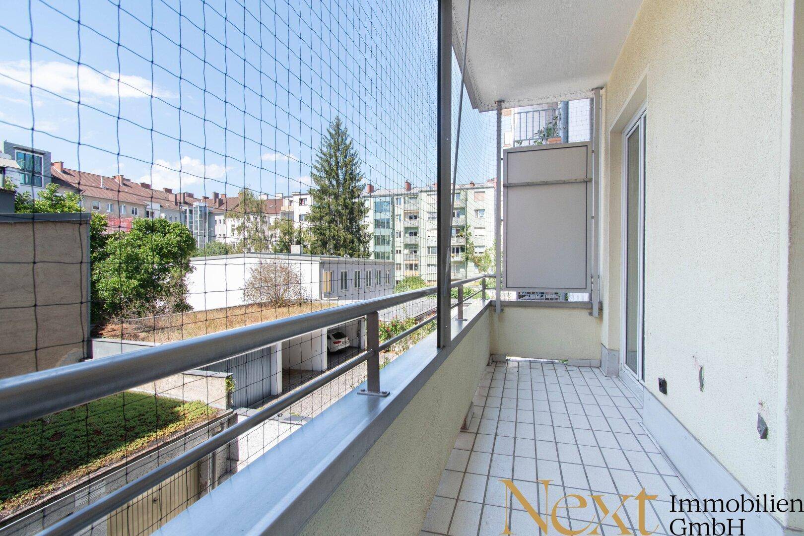 Geräumiger Balkon mit Fliesenboden und weitem Blick über die städtische Umgebung.
