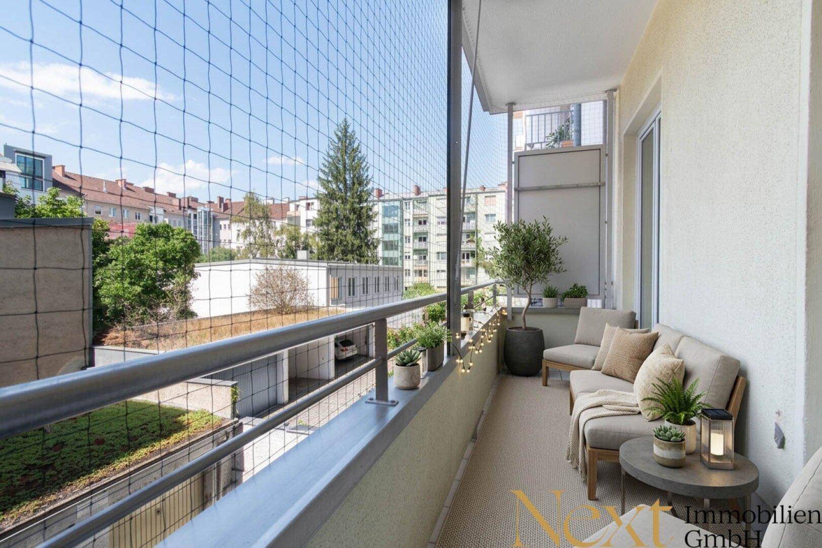 Möblierter Balkon mit Sitzgelegenheiten, Pflanzen und Blick auf die Umgebung.