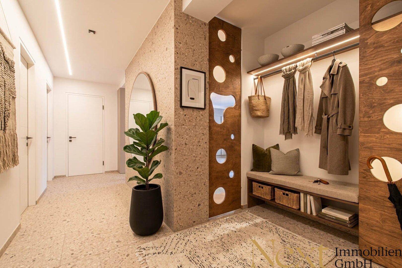 Moderner Flur mit Terrazzo-Boden, Garderobe und dekorativer Wandgestaltung.