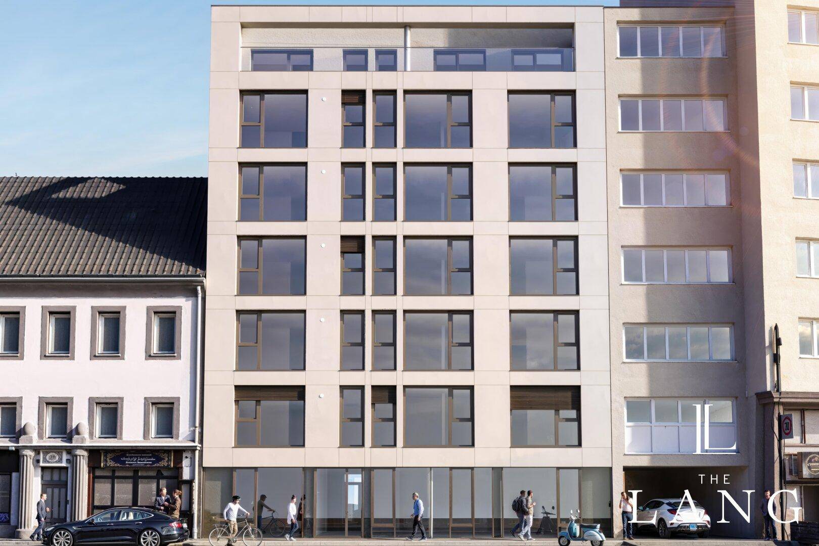 Moderne Gebäudefassade mit großen Fenstern und Geschäften im Erdgeschoss in urbaner Umgebung.