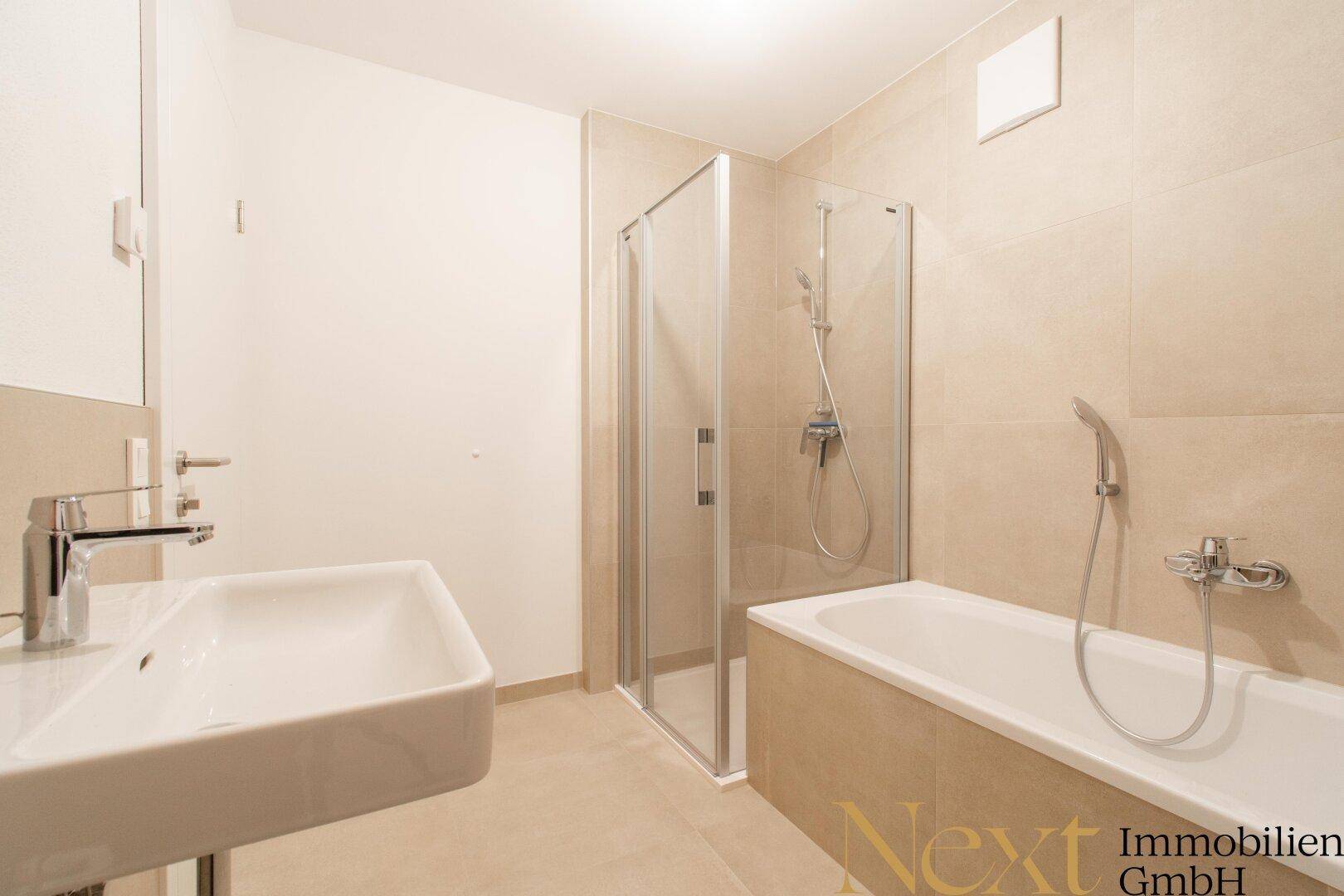 Zeitgemäßes Badezimmer mit Duschkabine, Badewanne und modernem Waschbecken.