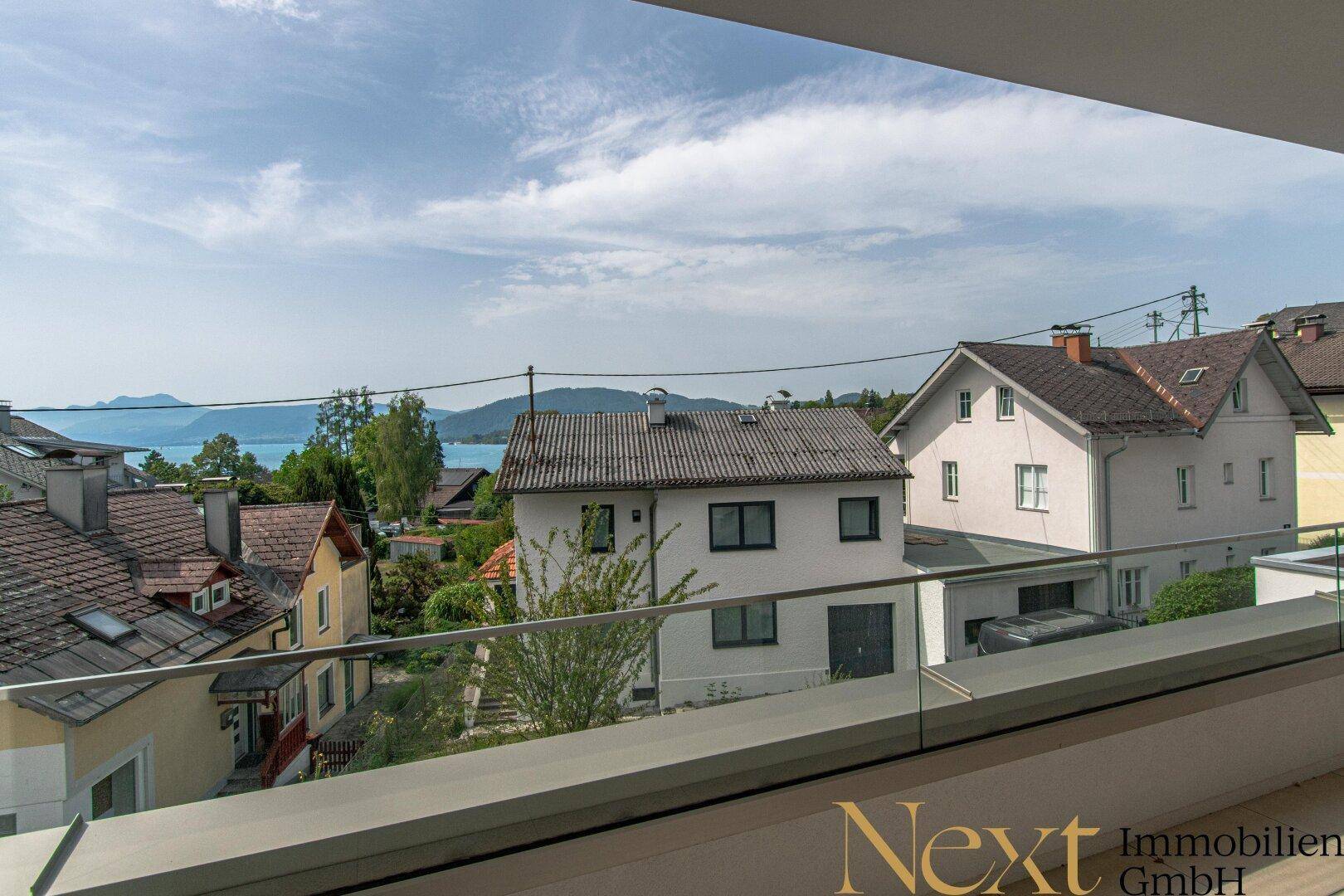 Balkon mit Panoramablick auf den See und die umliegende Wohnbebauung.