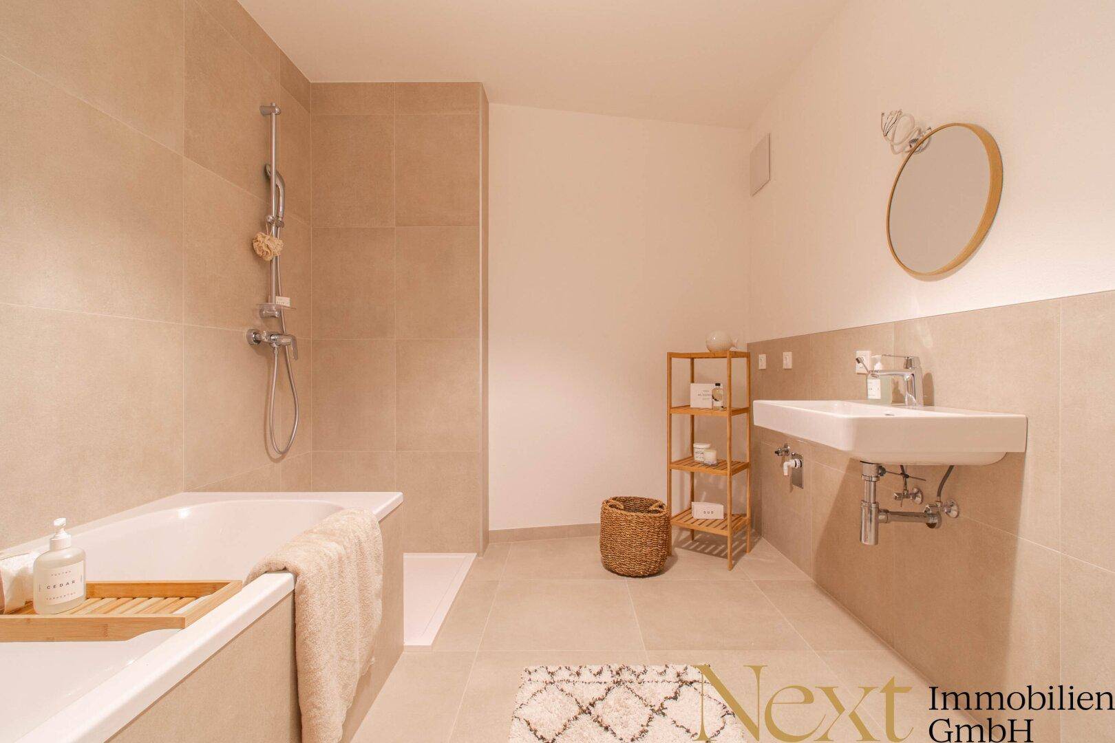 Helles Badezimmer mit Badewanne, Dusche und modernem Waschbecken.