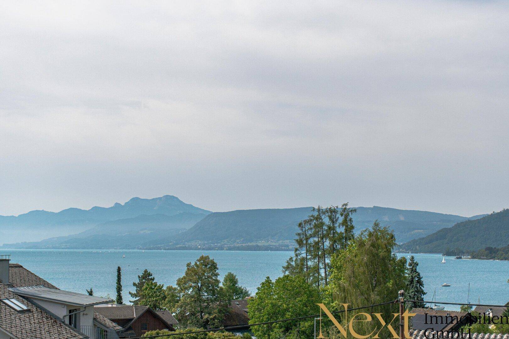 Panoramablick auf den See und die majestätischen Berge, umgeben von üppigem Grün.