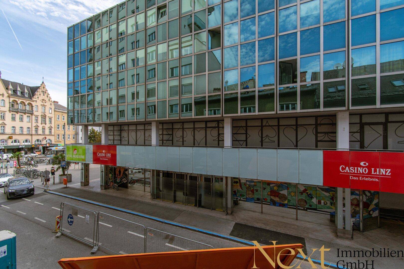 Stadtansicht mit einem modernen Gebäude, das ein Casino beherbergt, und belebter Straße.