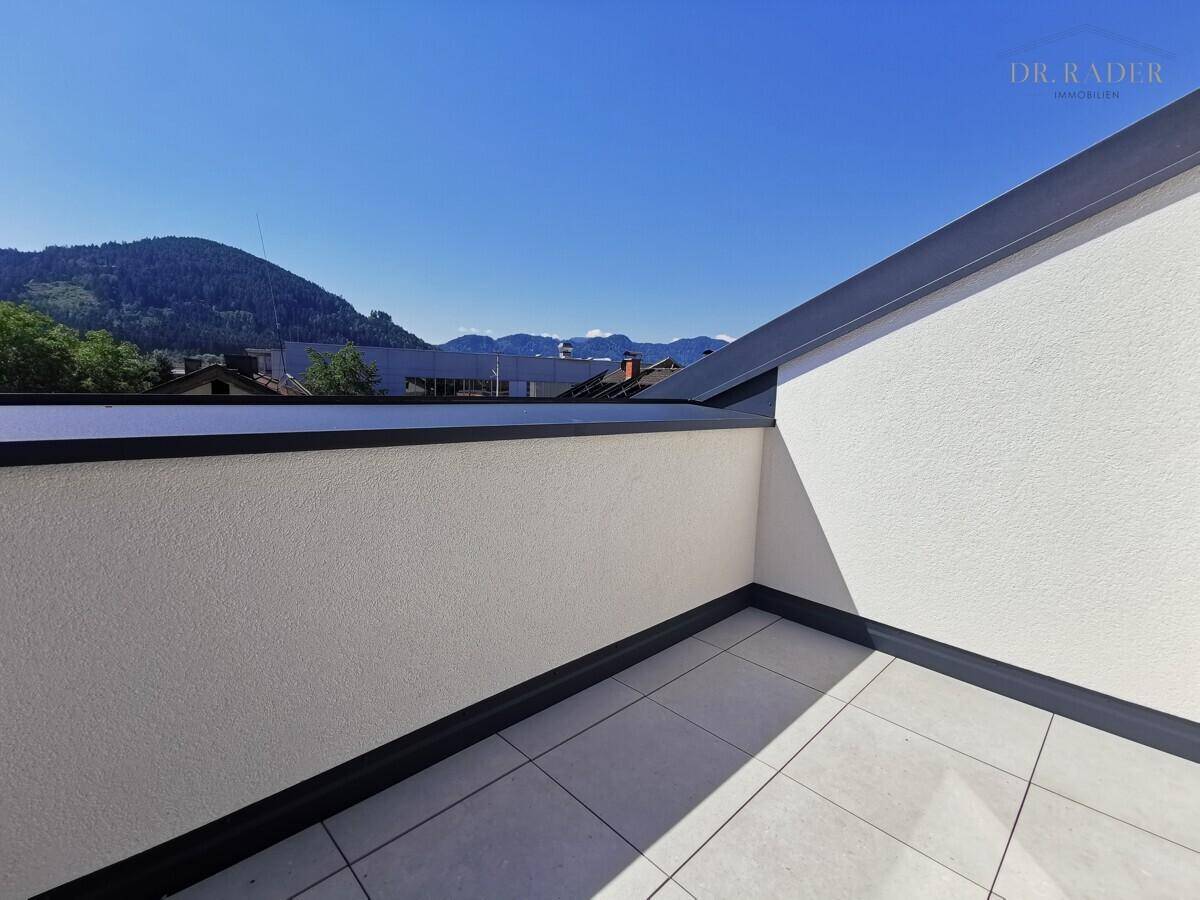 Sonniger Balkon mit Fliesenboden und weitem Blick auf die umliegenden Berge.