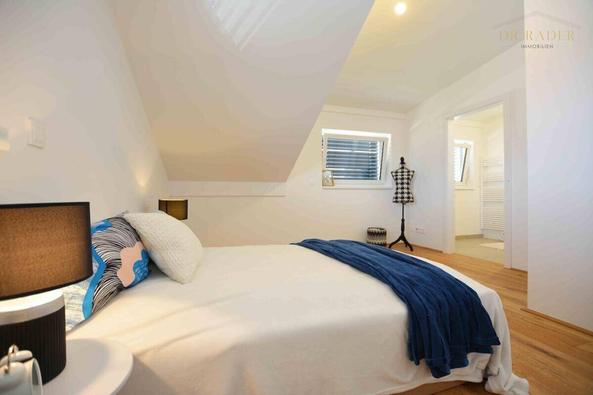 Gemütliches Schlafzimmer mit Dachschräge und direktem Zugang zum Badezimmer.