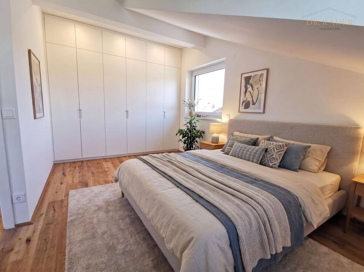 Gemütliches Schlafzimmer mit Einbauschränken, Holzboden und Dachschräge für optimalen Komfort.