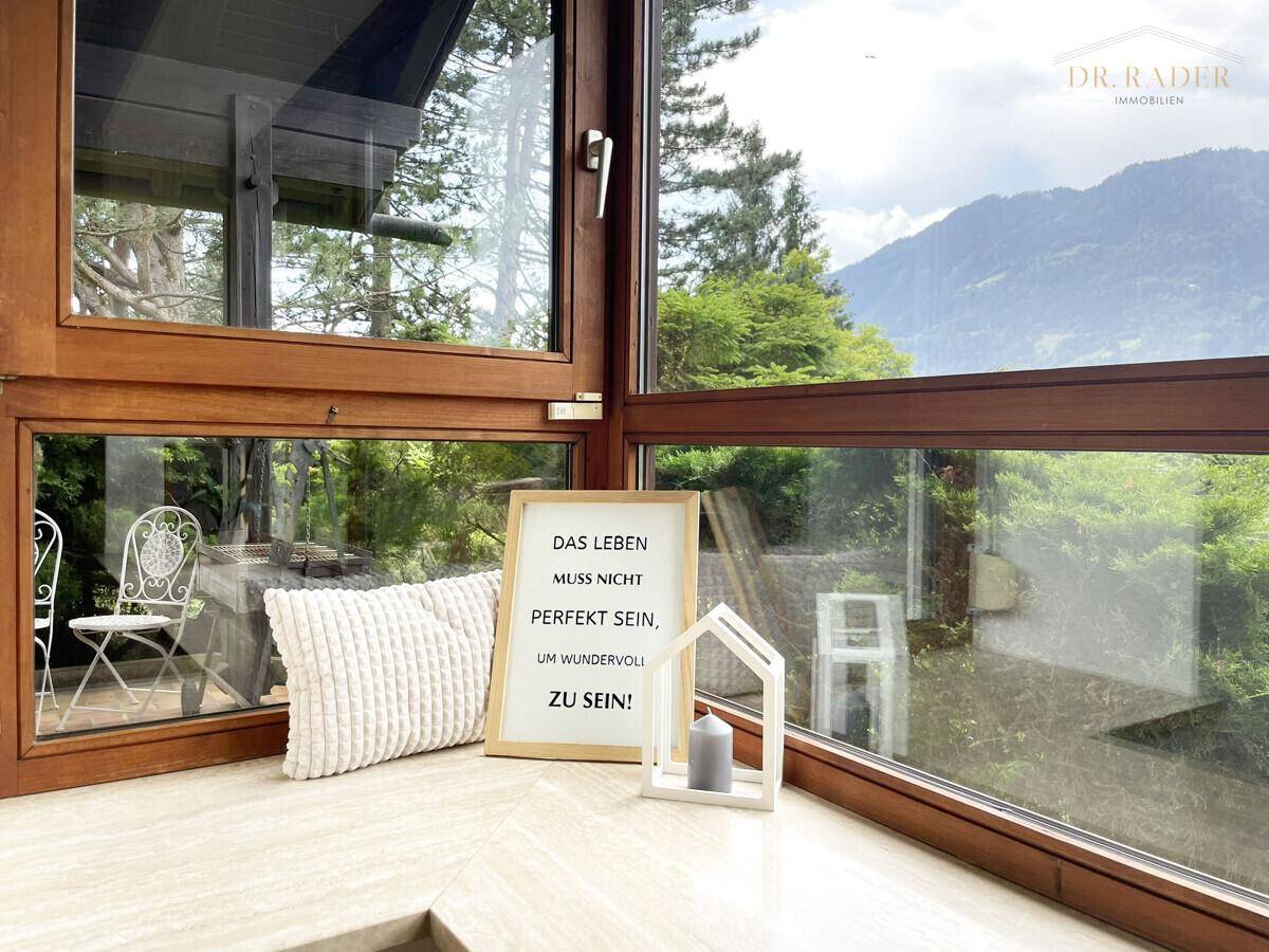 Gemütlicher Erkerbereich mit großen Fenstern und inspirierendem Bergblick, ideal zum Entspannen.