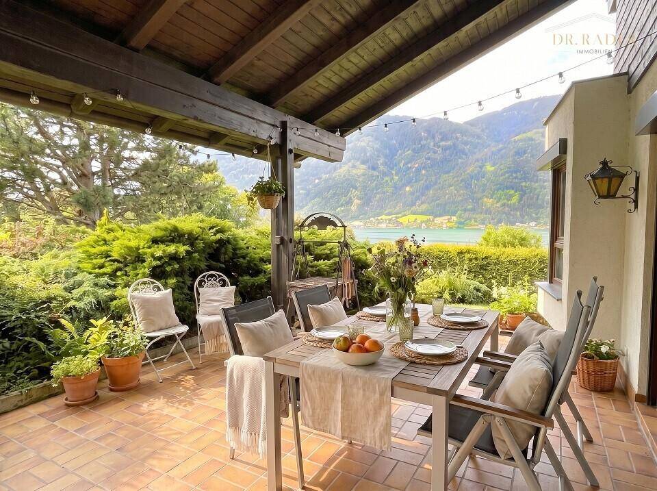 Überdachte Terrasse mit Esstisch und Stühlen, bietet einen wunderschönen Blick auf den See.