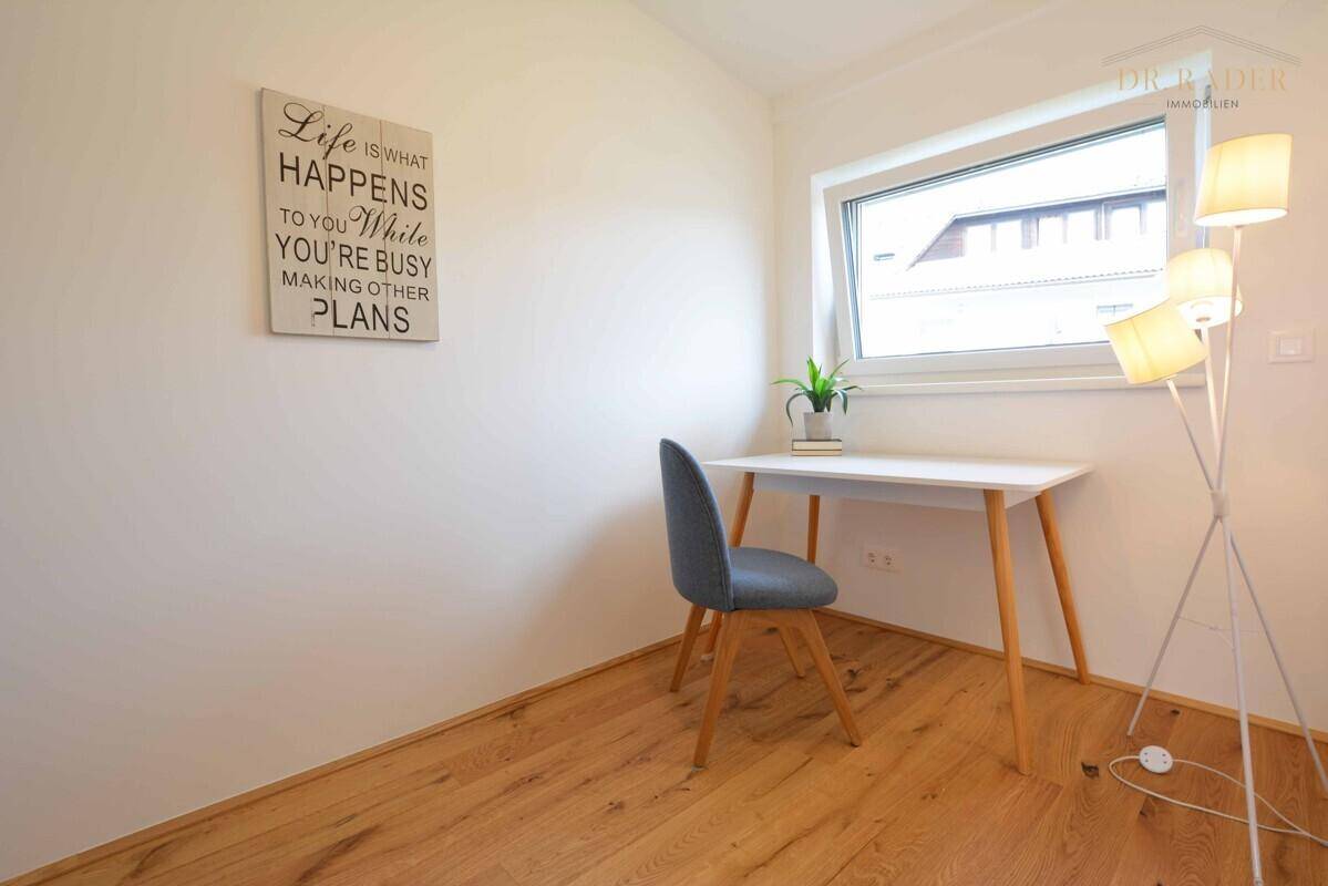 Helles Arbeitszimmer mit Schreibtisch, Stuhl und Holzboden, ideal für Home-Office.