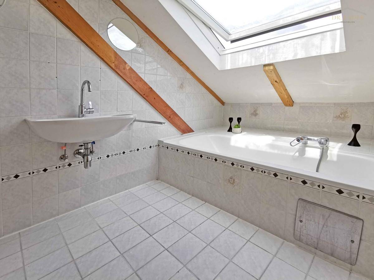 Badezimmer mit Wanne und Fenster