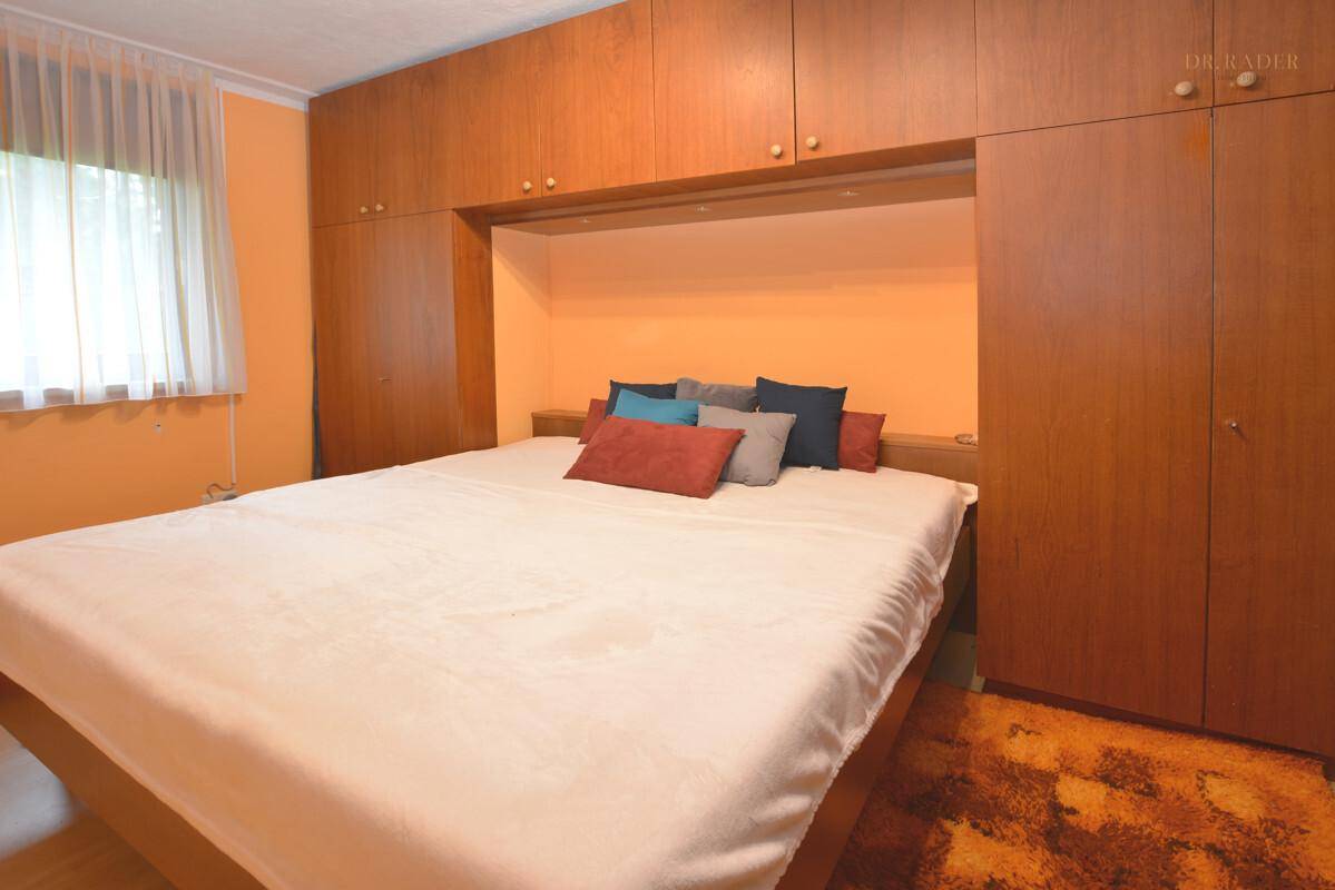 Schlafzimmer mit großem Doppelbett und integrierten Holzschränken.