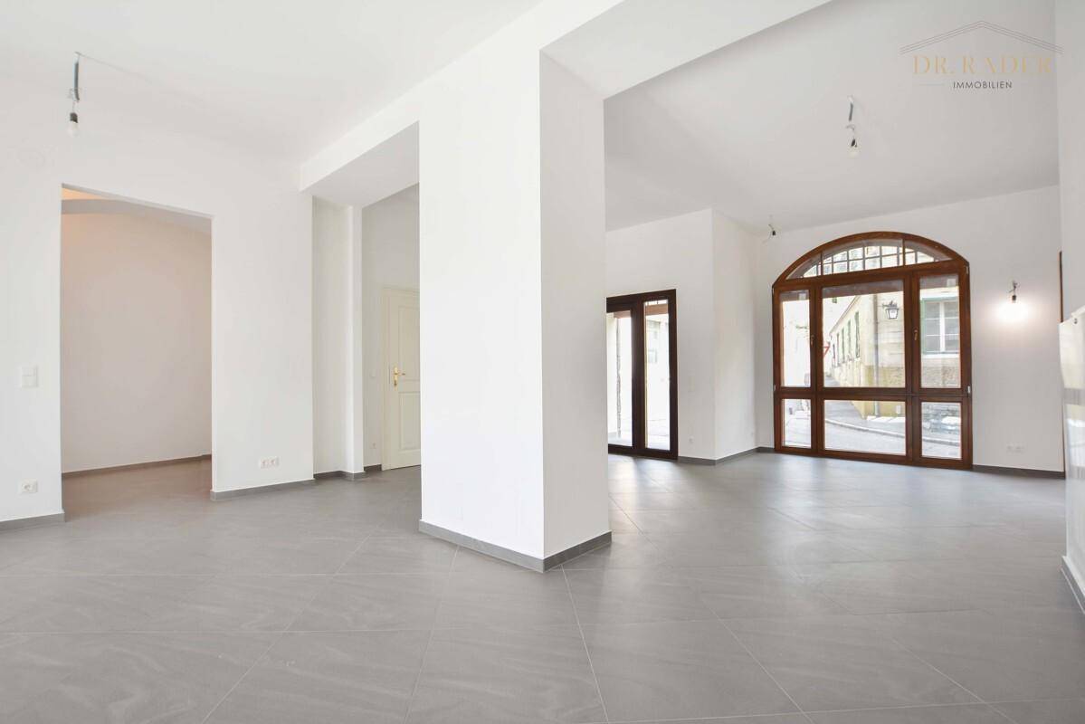 Heller Gewerberaum mit Säulen, großen Fenstern und modernem Fliesenboden, ideal für verschiedene Geschäftskonzepte.