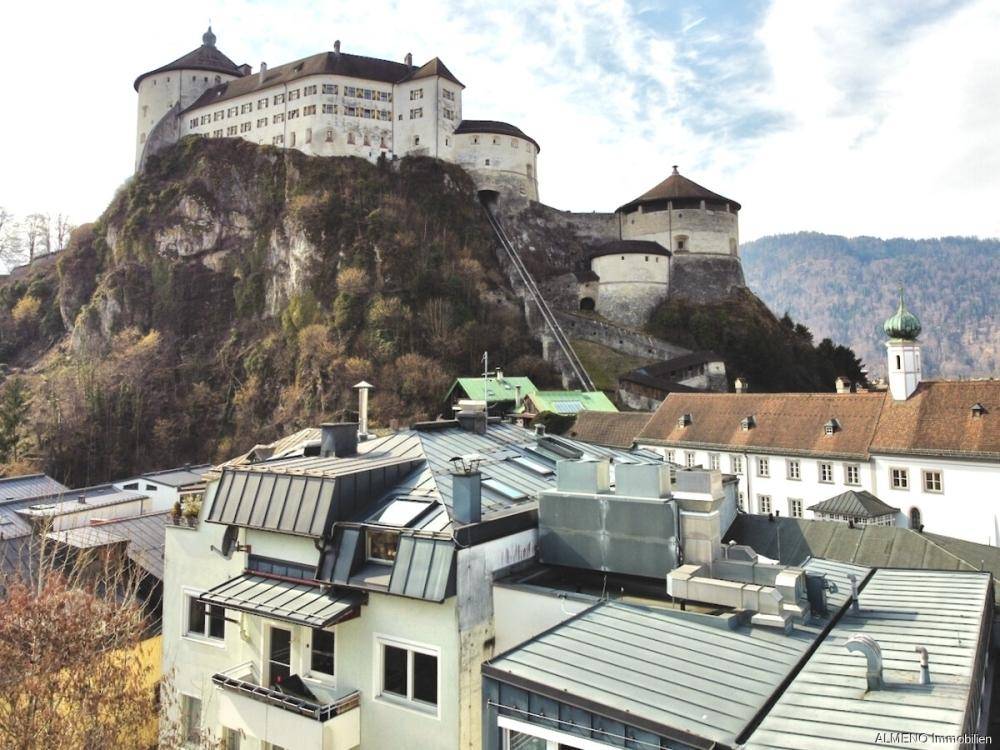 Blick über die Dächer der Stadt mit der majestätischen Burg auf dem Felsen im Hintergrund.