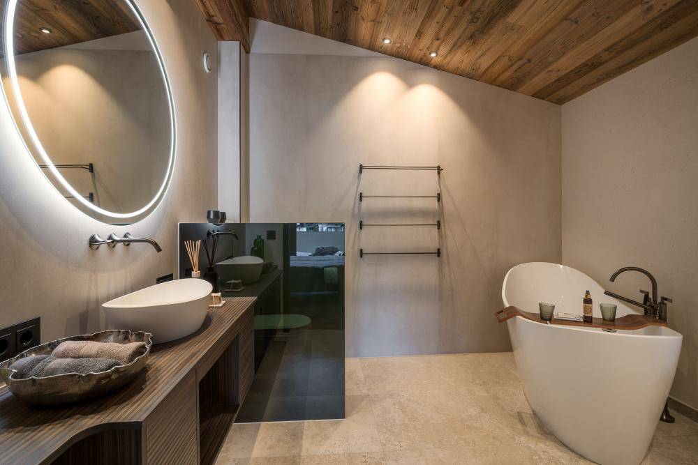 Modernes Badezimmer mit freistehender Badewanne, Doppelwaschbecken und Holzbalkendecke.