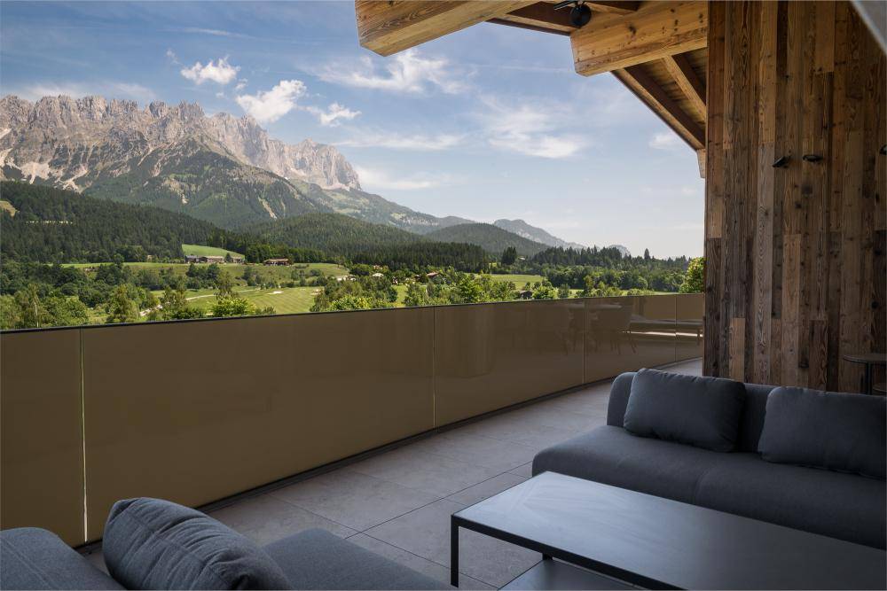 Großer Balkon mit bequemen Outdoor-Sofas und weitem Blick auf die umliegende Bergwelt.