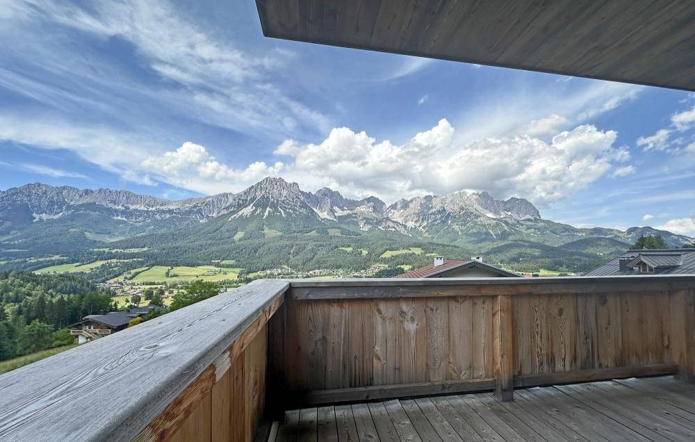 Geräumiger Holzbalkon mit atemberaubendem Panoramablick auf die Berglandschaft.