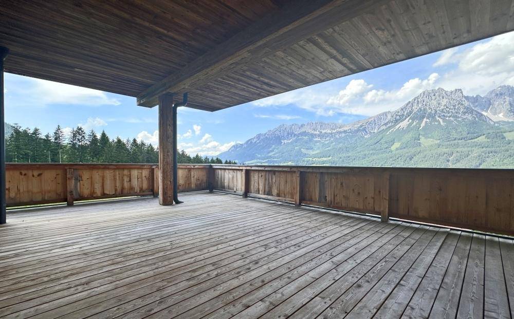 Große Holzterrasse mit weitem Blick auf die umliegende Berglandschaft.