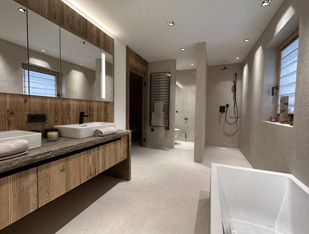 Modernes Badezimmer mit Doppelwaschbecken, begehbarer Dusche und Badewanne.