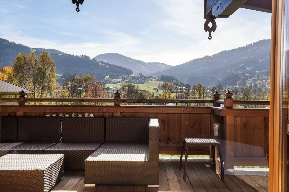 Geräumiger Balkon mit Sitzgelegenheiten und Panoramablick auf die Berge und das Tal.