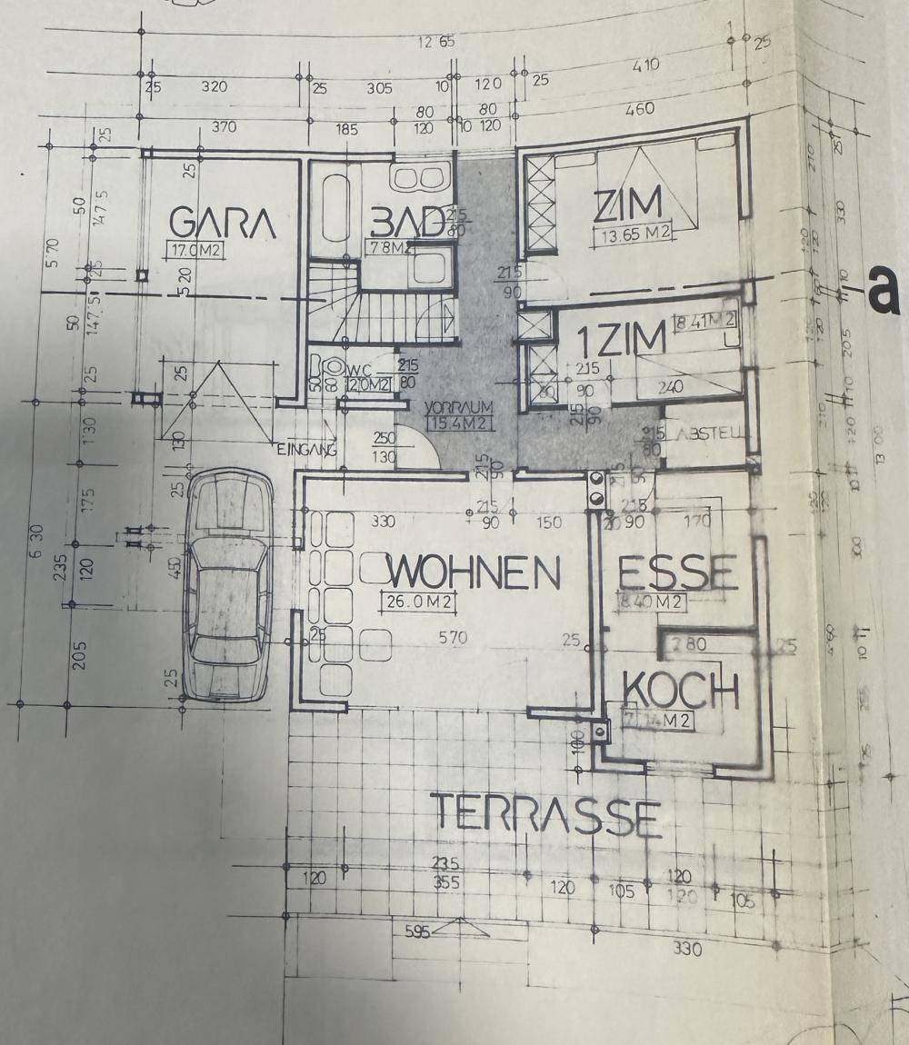 Grundriss des Erdgeschosses mit Wohn-, Ess- und Kochbereich, Bad, Schlafzimmer, Garage und Terrasse.