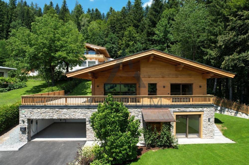 Attraktives Holzhaus mit Steinfassade, integrierter Doppelgarage und gepflegtem Garten.