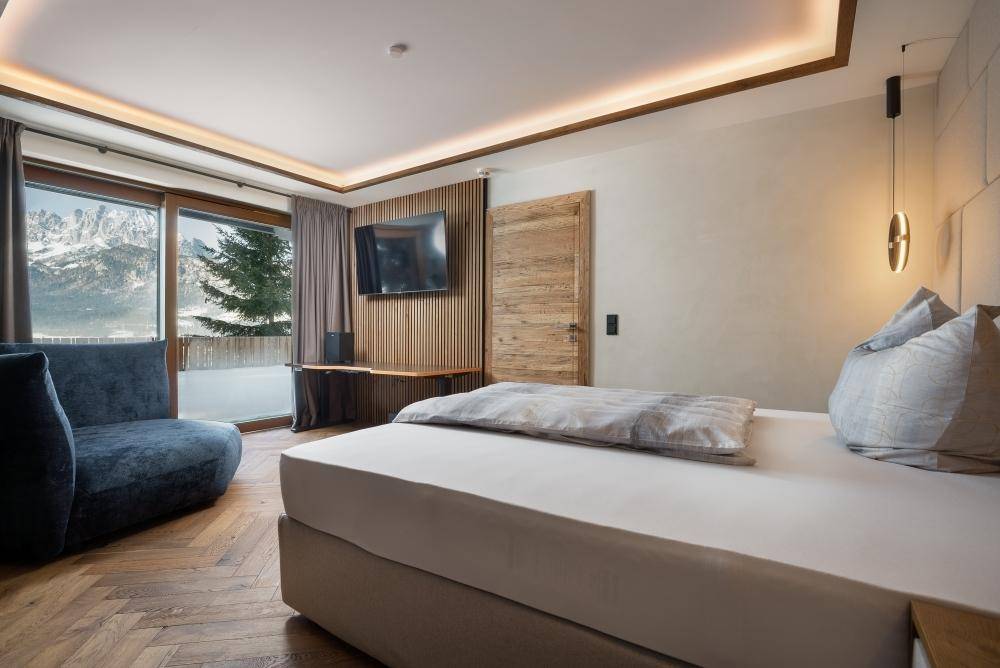 Modernes Schlafzimmer mit Zugang zum Balkon und stilvoller indirekter Beleuchtung.