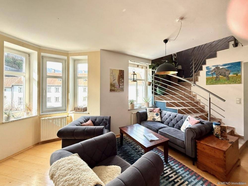 Gemütlicher Wohnbereich mit bequemen Sofas, Holzboden und großen Fenstern mit Ausblick.