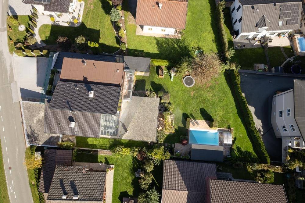 Luftaufnahme des Anwesens mit großem Garten, Pool und Trampolin, umgeben von weiteren Wohnhäusern.