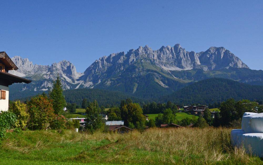 Malerischer Panoramablick auf die majestätischen Berge und die umliegende grüne Landschaft mit Häusern.