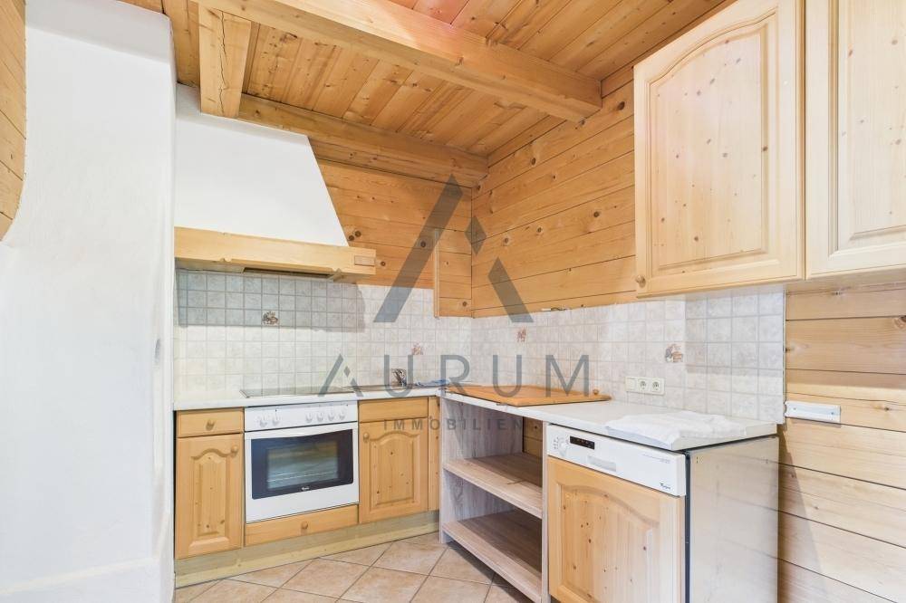 Rustikale Küche mit Holzwänden, Holzschränken und integriertem Backofen sowie Spülmaschine.
