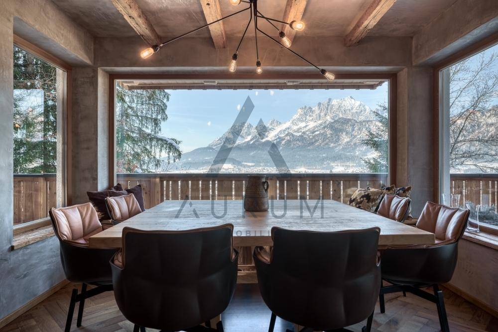 Gemütlicher Essbereich mit Holztisch, bequemen Stühlen und beeindruckendem Bergblick.